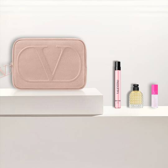 Kit beaute Valentino : pochette rose, parfums et produit levres sur blanc.