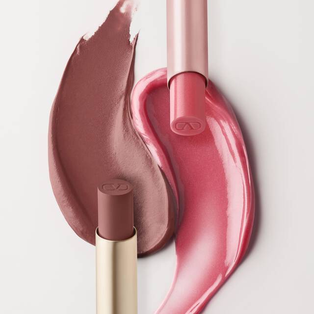Une image divisee montrant des produits cosmetiques. A gauche, deux echantillons de produits pour les levres roses sont visibles, l'un d'un rose-brun plus clair et l'autre d'un rose plus vif et brillant. Un tube de baume a levres Valentino Spike et un tube de gloss sont positionnes a cote. Le cote droit presente une boite de Spike Valentino Disco Balm et une boite de Spike Valentino Matte, avec leurs echantillons de couleur respectifs disposes en dessous.